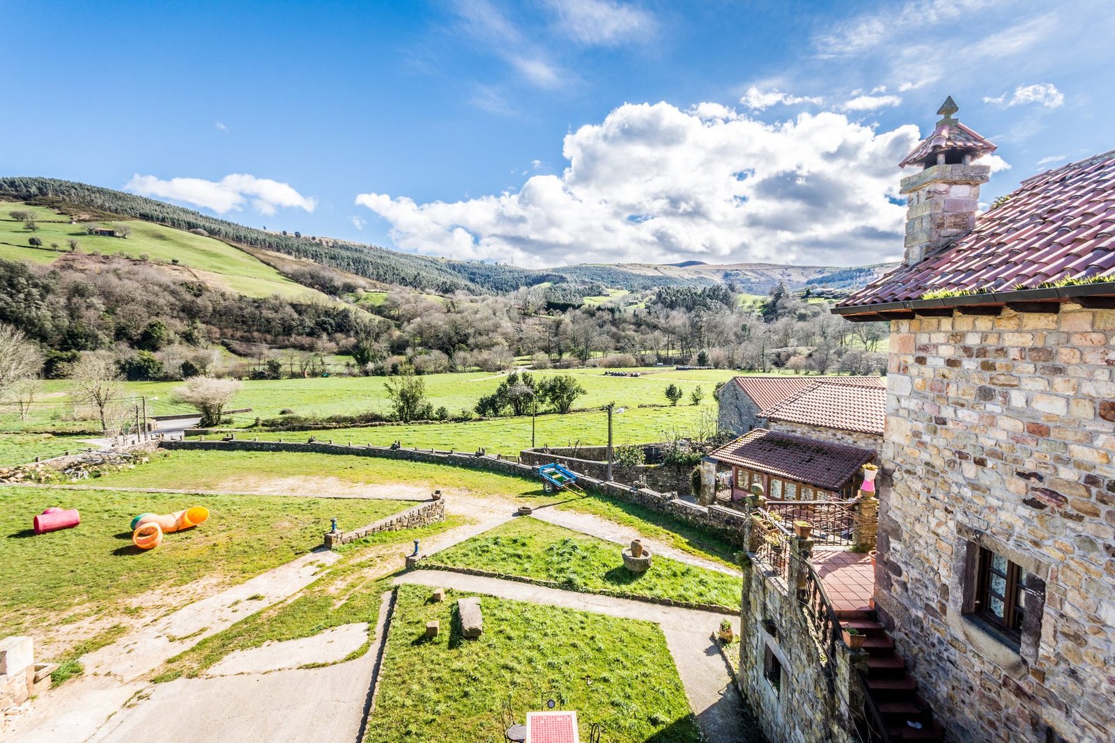 Vista panorámica desde Finca Gándara de jardines, prados verdes y colinas de Cantabria